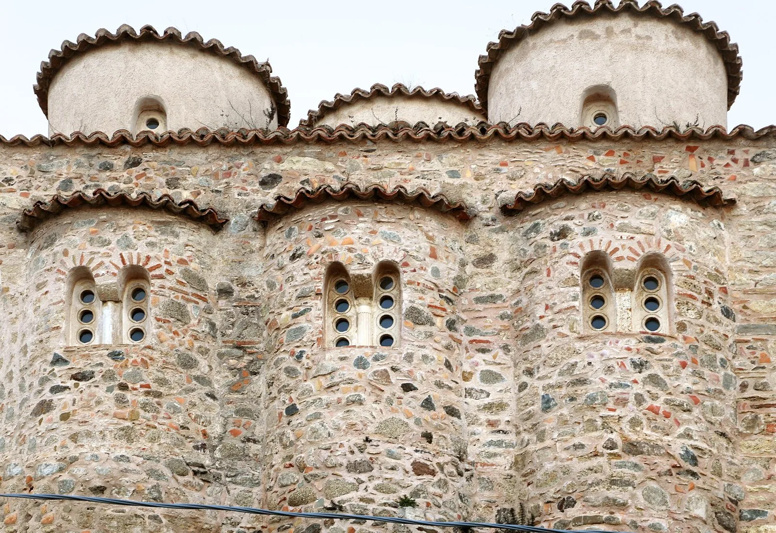 Le tre absidi in pietra con bifore e le cupolette della chiesa bizantina di San Marco a Rossano