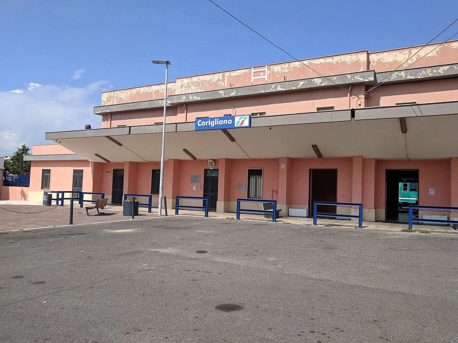 Fabbricato viaggiatori rosa della stazione ferroviaria di Corigliano con l'insegna FS
